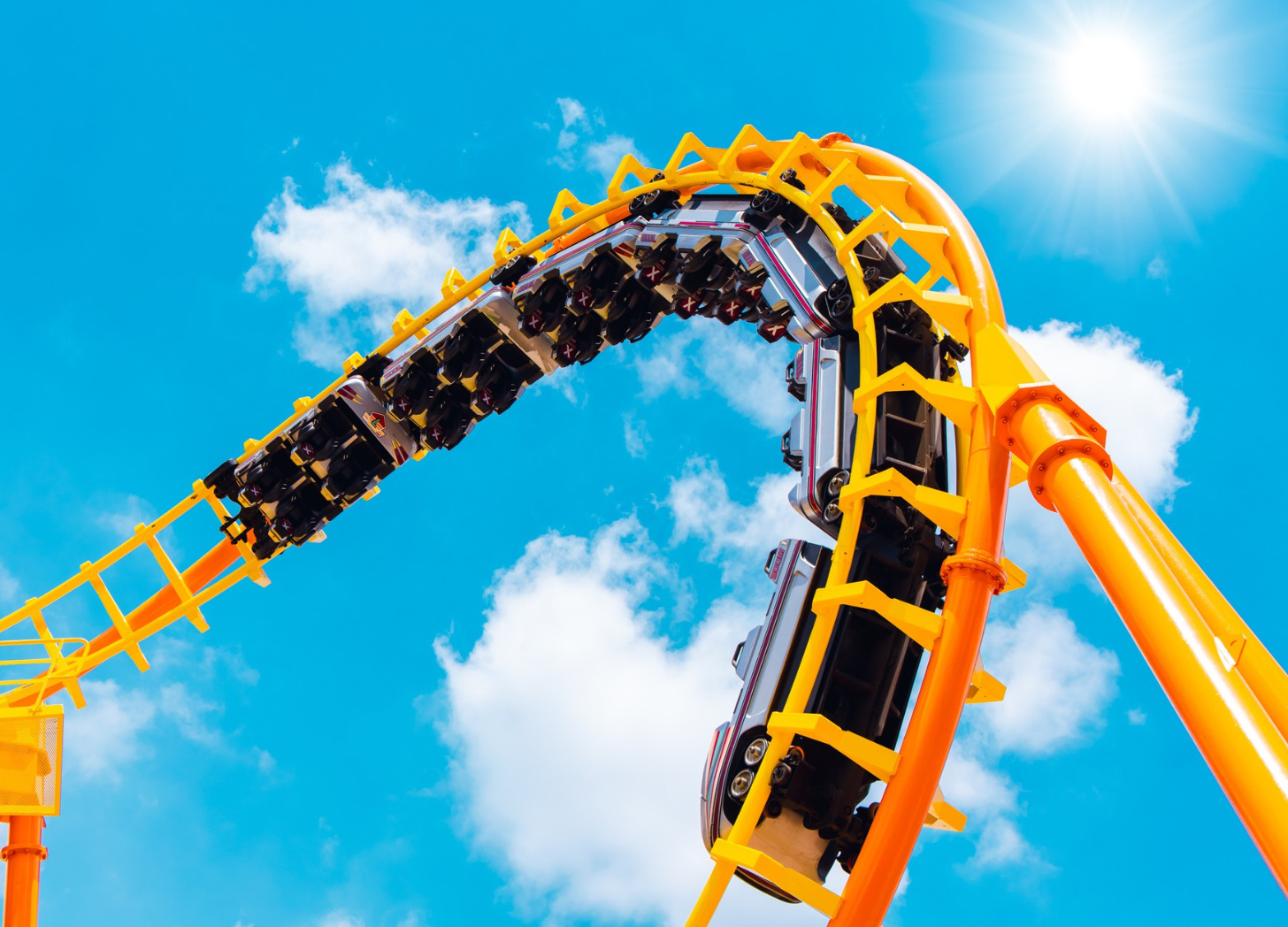 Yellow roller coaster against a blue sky